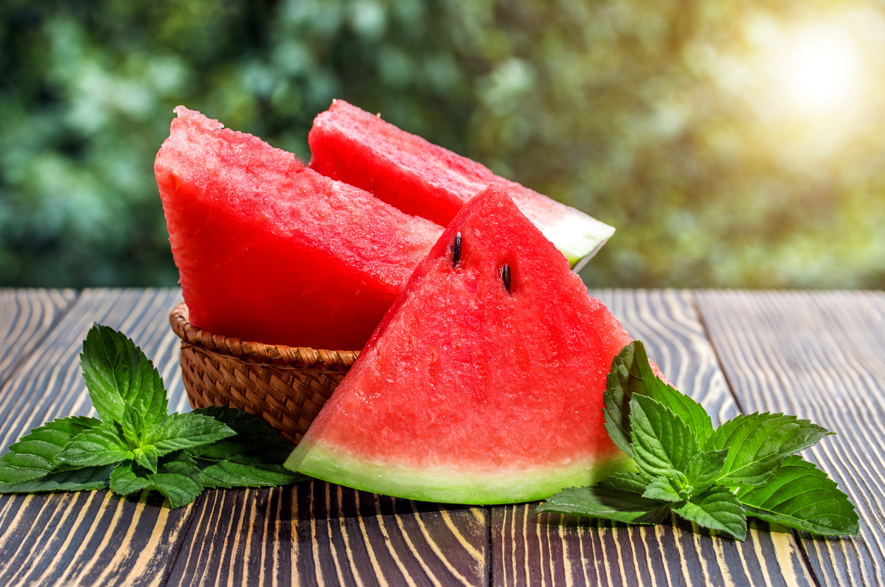 Fresh sliced watermelon wooden background Arbūzų sezono startui – keli triukai: kodėl verta padėti pirštą ant žievės ir kam pasitarnaus druska