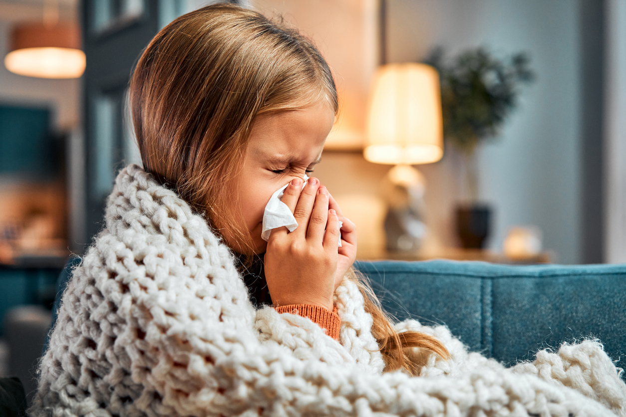 Season of flu. Little kid covered with blanket pressing handkerchief to nose while sneezing at apartment Medikė perspėjo dėl pneumokokinės infekcijos pavojų ir įvardijo vienintelę patikimą prevencinę priemonę