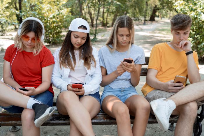 Jaunimas_mobilieji_medium_shot_group_friends_phones EP: socialiniai tinklai ir DI asistentai vaikams – nuo 16 metų