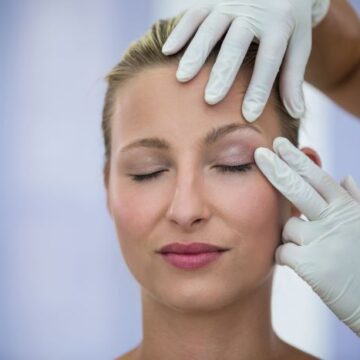 Plastine_doctor_examining_female_patients_face_from_cosmetic_treatment_2 „Jei reikia įkalbinėti gydytoją – vadinasi, operacijos nereikia“: plastikos chirurgas Darius Radzevičius apie ribas, atsakomybę ir natūralumą